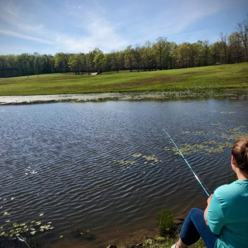 Child relaxing by fishing at a pond