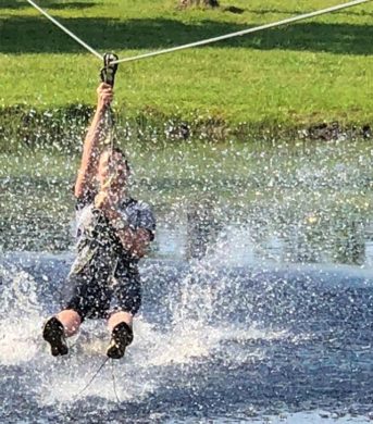 person ziplining and splashing water