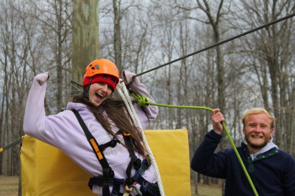 woman landing at the end of the zipline