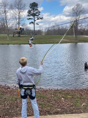 zipliner upside down over lake