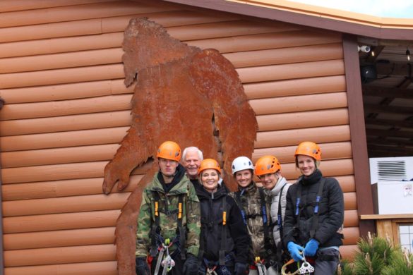 family preparing to zipline in front of bigfoot