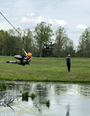 two zipliners over a lake
